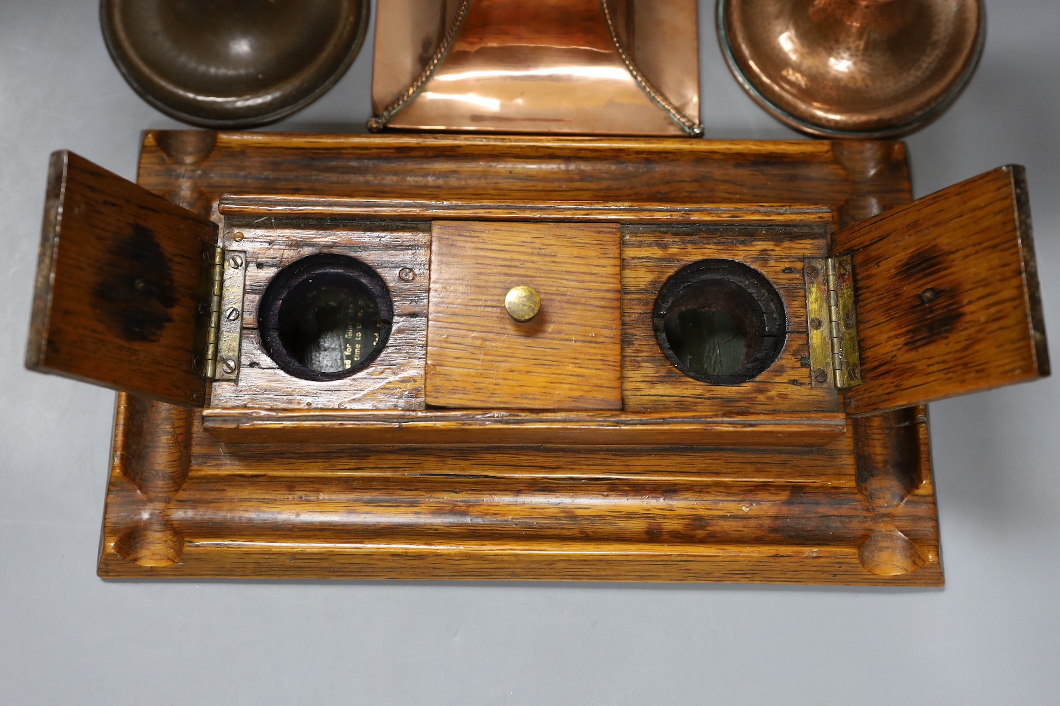 A copper Arts & Crafts inkwell, a pair of A Jones turned candlesticks and an early 20th century oak ink stand (4)